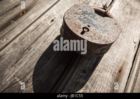 Alte große verrostete Vorhängeschloss an ländlichen Holztür hängen Stockfoto