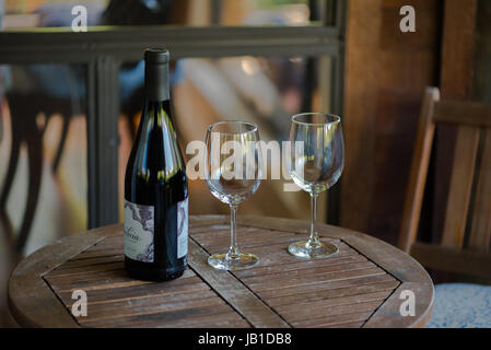 Eine Flasche Wein und zwei Gläser auf einem Holztisch Stockfoto