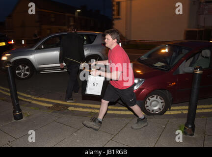 Wahl Personal tragen Wahlurnen vor die Anzahl der für die Parlamentswahlen in Brangwyn Hall in Swansea. Stockfoto