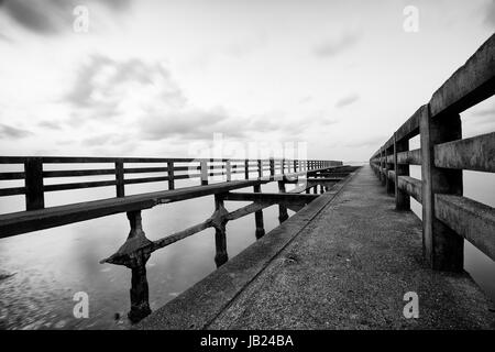 Langzeitbelichtung einer alten Brücke in kambodschanischen Strand - Kep - Ruine Brücke in schwarz / weiß Stockfoto