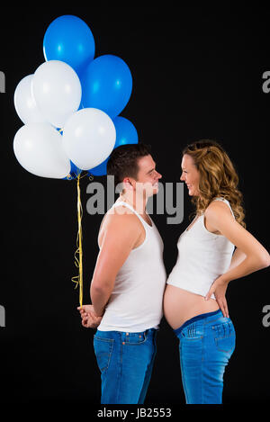 Der Mann gibt seine schwangere Frau Ballons Stockfoto