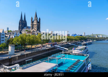 Rhein, Groß St. Martin Kirche (Groß Sankt Martin) & Kölner Dom von der Deutzer Brücke, mit Flusskreuzfahrt Boot vor, Köln, Deutschland Stockfoto