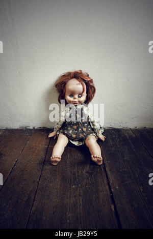 Gruselige Vintage Puppe auf Holzboden Stockfoto