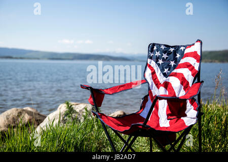 American flag Campingstuhl am See für 4. Juli Feier Stockfoto