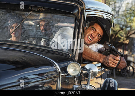 1920er Jahre Gangster Schießen Pistole vom Autofenster Stockfoto