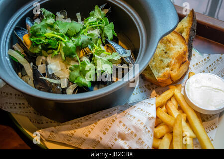 Hoegaarden Muscheltopf gehackt, Koriander, Fenchel, Zitronenschale und Hoegaarden Bier Pommes frites Stockfoto