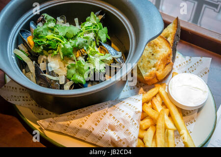 Hoegaarden Muscheltopf gehackt, Koriander, Fenchel, Zitronenschale und Hoegaarden Bier Pommes frites Stockfoto