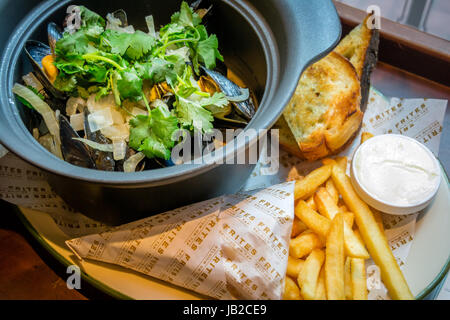 Hoegaarden Muscheltopf gehackt, Koriander, Fenchel, Zitronenschale und Hoegaarden Bier Pommes frites Stockfoto