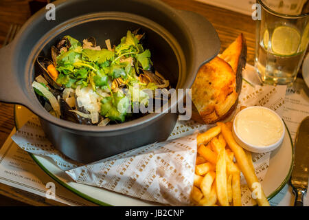 Hoegaarden Muscheltopf gehackt, Koriander, Fenchel, Zitronenschale und Hoegaarden Bier Pommes frites Stockfoto