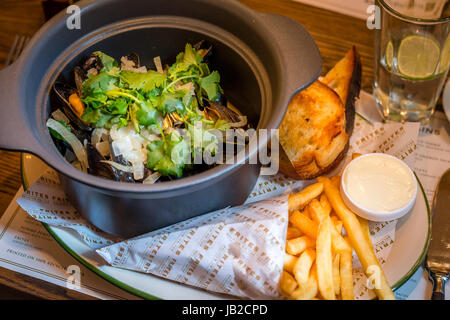 Hoegaarden Muscheltopf gehackt, Koriander, Fenchel, Zitronenschale und Hoegaarden Bier Pommes frites Stockfoto