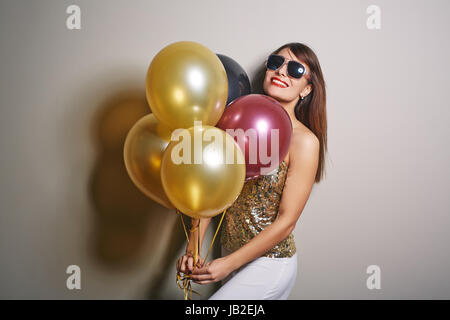 Hübsche Frau mit Haufen Luftballons Stockfoto