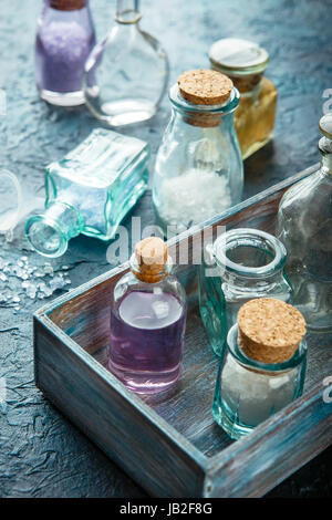 Kleine Glasflaschen mit aromatischen Salz und Parfümöl. Set für Aromatherapie in einer Holzkiste. Stockfoto