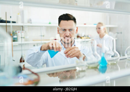 Moderne Wissenschaftler arbeiten im Labor mit Reagenzgläsern und reagieren Stockfoto