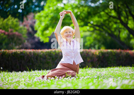 Wellness. Psychische Gesundheit. Optimistische alte Frau trainieren unter freiem Himmel Stockfoto