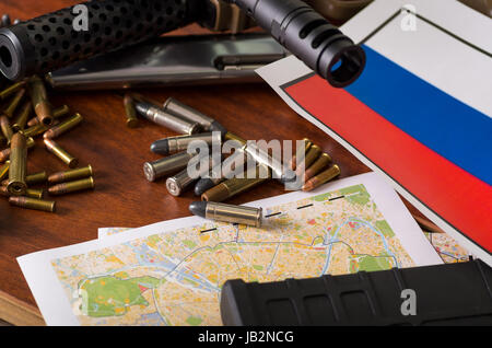 Nahaufnahme von einer Schrotflinte und einem Revolver, Patronengürtel mit Kugeln mit der russischen Flagge auf einer Karte auf Holztisch. Stockfoto