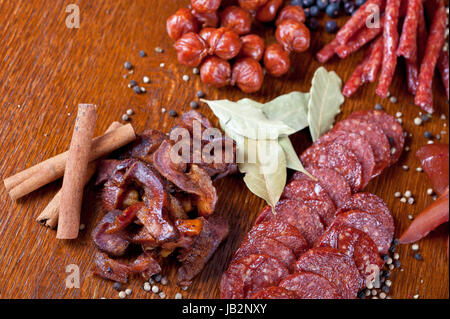 verschiedenen Wurst und Fleisch auf dem festlichen Tisch mit Gewürzen und Gemüse Stockfoto