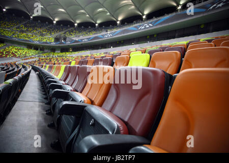 Leere Sitzreihen in verschiedenen Farben in einem Stadion Stockfoto