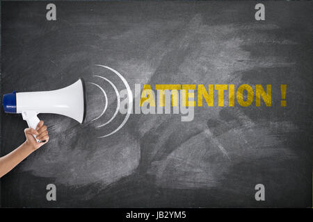 Frau mit einem Megaphon vor Tafel mit Aufmerksamkeit text Stockfoto