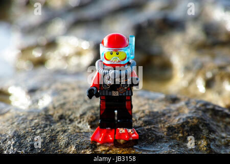 Paphos, Zypern - 9. Oktober 2016 Lego Minifigur auf Stein im Meer Taucher stehen. Stockfoto