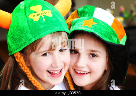 Zwei Mädchen, Kinder umarmen tragen St. Patrick's Day in Dublin Irland Stockfoto