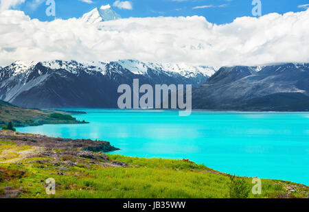 Mächtigen Mt. Cook erscheint aus den Wolken in der Nähe von der unglaublich blauen Lake Pukaki bei New Zealand Stockfoto