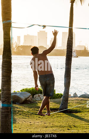 Miami Beach, Florida, South Pointe Park, am Wasser, Slacklining, Drahtseilwanderungen, Erwachsene Erwachsene Männer Männer, Balancing, Besucher reisen auf Reisetour Stockfoto