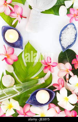 Spa-botanische tropische Konzept Kräuter Salz Kokosöl und Plumeria Blumen auf tropisches Blatt Hintergrund flach legen Draufsicht Stockfoto