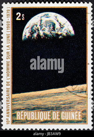 Republik GUINEA - ca. 1979: Eine Briefmarke gedruckt in der Republik Guinea zeigt die Apollo 11 Mondlandung und der erste Schritt auf der Mondoberfläche - Blick auf die Erde, ca. 1979 Stockfoto