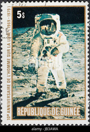 Republik GUINEA - ca. 1979: Eine Briefmarke gedruckt in der Republik Guinea zeigt die Apollo 11 Mondlandung und Amstrong zunächst auf der Mondoberfläche, ca. 1979 Stockfoto