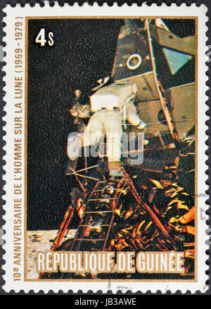 Republik GUINEA - ca. 1979: Eine Briefmarke gedruckt in der Republik Guinea zeigt die Apollo 11 Mondlandung und der erste Schritt auf der Mondoberfläche - fliegen auf dem Mond, ca. 1979 Stockfoto