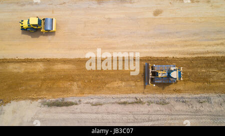 Luftaufnahme von einem Baggerlader und eine Dampfwalze auf einer Baustelle in der Nähe von Vue, Loire-Atlantique, Frankreich Stockfoto