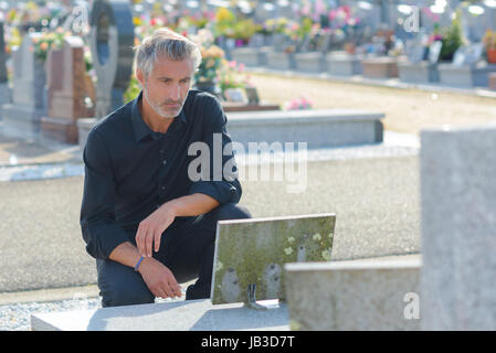 Grabstein im Friedhof Blumen indem Mann Stockfoto