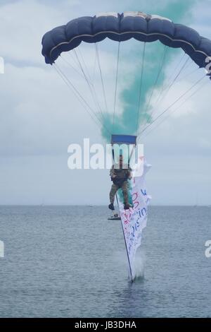 Die tigres Freefall Fallschirm Display Team, Torbay Airshow 2016. Nasse Landung mit grünem Rauch. Paignton, Devon, Großbritannien. Stockfoto