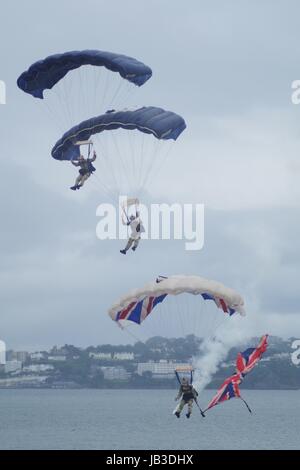 Die tigres Freefall Fallschirm Display Team, Torbay Airshow 2016. Trio in Synchronisierung mit Union Flag und Rauch Trail. Nasse Meer Landung. Devon, UK. Stockfoto