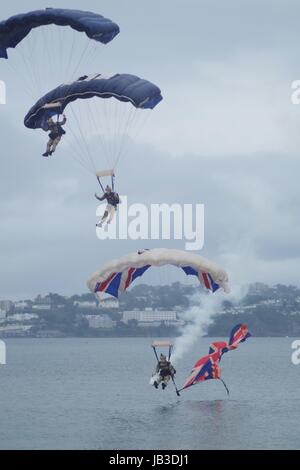 Die tigres Freefall Fallschirm Display Team, Torbay Airshow 2016. Trio in Synchronisierung mit Union Flag und Rauch Trail. Nasse Meer Landung. Devon, UK. Stockfoto