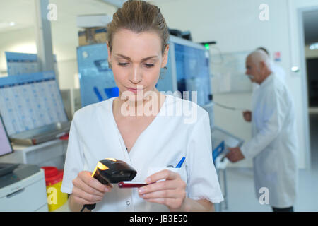 Krankenschwester Überprüfung Bestandsmengen in der Krankenhausapotheke mit scanner Stockfoto