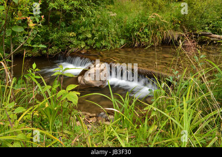 durch den Stein unten fließt der Fluss schnell Stockfoto