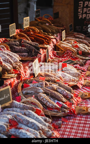 Schalen mit traditionellen Fleisch- und Wurstwaren gestapelt angezeigt in Weidenkörbe für den Verkauf auf einen Stand auf einem lokalen Markt in der Altstadt in Annecy, Frankreich Stockfoto