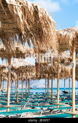 Sonnenschirme und Liegestühle am Strand von Elafonissi, Kreta, Griechenland Stockfoto