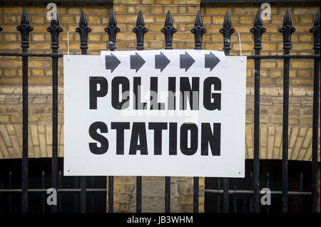 Wahlen in Großbritannien Wahllokal Schild hängen auf klassische Schmiedeeisen Zaun vor der gelben Wand in London, UK Stockfoto