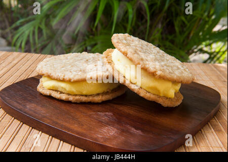 Vegane Kokos Mango und Haferflocken Cookies Eis Sandwiches im Freien in den Tropen Stockfoto