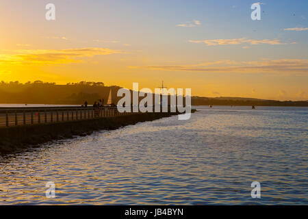 Mount Batten Pier vom Meer Ozean abgehen in Ferne am goldenen Sonnenuntergang segeln Yachten in Plymouth Sound, Devon, England, UK Stockfoto