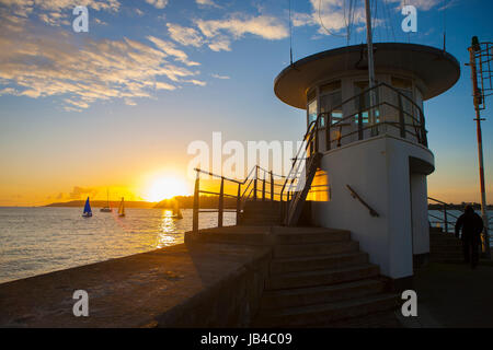 Mount Batten Pier vom Meer Ozean abgehen in Ferne am goldenen Sonnenuntergang segeln Yachten in Plymouth Sound, Devon, England, UK Stockfoto