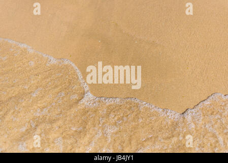 schäumende Meerwasser Rollen über den Strand Stockfoto