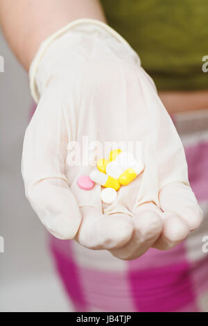 einige Tabletten in behandschuhten Hand hautnah Stockfoto