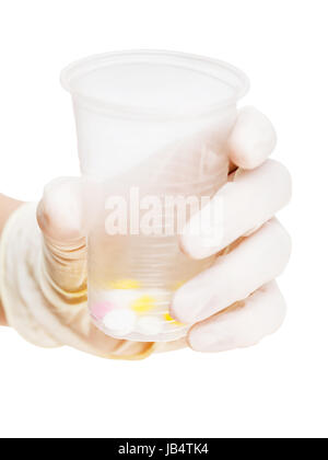 behandschuhten Hand hält Plastikbecher mit Tabletten isoliert auf weißem Hintergrund Stockfoto