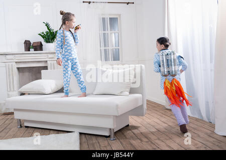 Mädchen im Schlafanzug spielen Kosmonauten zu Hause Stockfoto