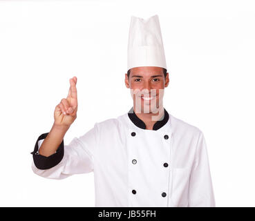 Porträt von einer attraktiven männlichen Koch auf weiße uniform mit Glück Zeichen Lächeln Sie stehend auf isolierte studio Stockfoto