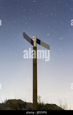 Küstenweg finger Wegweiser auf einem Wanderweg oberhalb in den Bergen unter einem Himmel mit Sternen gefüllt bei Nacht Stockfoto