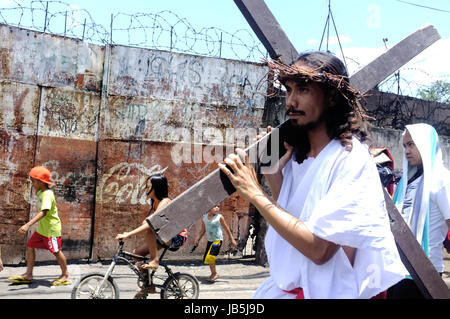 Cebu City, Philippinen - 3. April 2015. Eine Person gekleidet wie Jesus Parade die Straße mit seinem Kreuz während Ostern feiern in Cebu City. Stockfoto